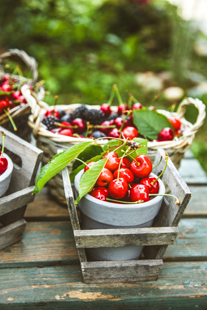 Fresh forest fruit on wood. Fresh organic fruit. Red cherries, blueberries and blackberriesの写真素材