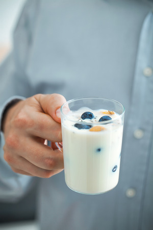 Healthy breakfast variety. Yogurt with fruit and seeds. Man with breakfastの写真素材