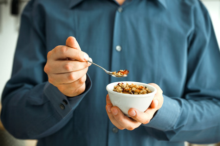 Healthy breakfast variety. Granola with fruit and seeds. Man with breakfast