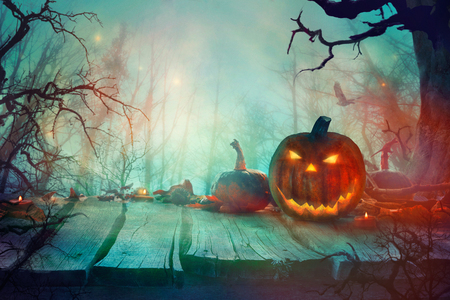 Halloween with Pumpkins and Dark Forest. Scary Jack O' Lantern Halloween Design on Tableの写真素材