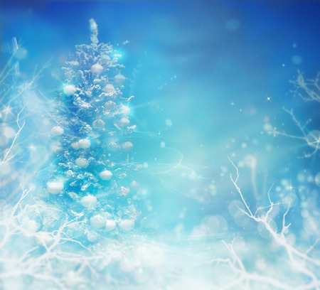 Winter frozen background. Winter Christmas concept with tree branches, snow and bokeh lights. Christmas tree in snow.の写真素材