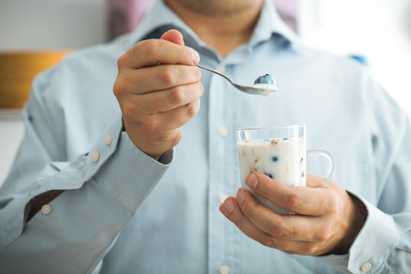 Healthy breakfast variety. Yogurt with fruit and seeds. Man with breakfastの写真素材