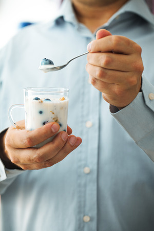 Healthy breakfast variety. Yogurt with fruit and seeds. Man with breakfastの写真素材