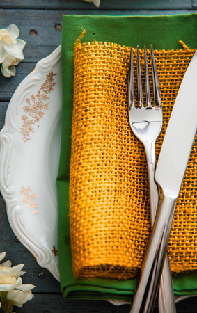 Spring table setting. Narcissus flower. Fork on Easter table. Holiday table settingの写真素材