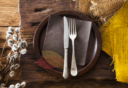 Spring table setting. Cutlery on wood. Fork and knife in plate. Flatlay overhead shotの写真素材