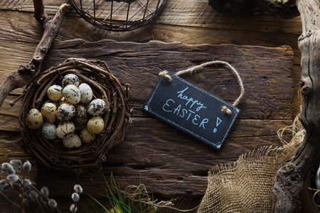 Easter table setting.Quail eggs in nest. Spring table. Happy Easter text on plateの写真素材