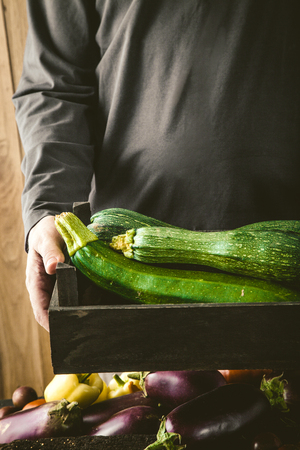 Organic vegetables. Farmers hands with freshly harvested vegetables. Fresh organic zucchini.の写真素材