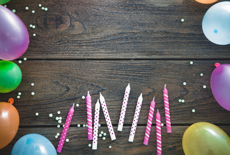 Birthday background. Colorful balloons and candles on wooden backgroundの写真素材