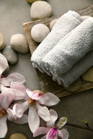 Spa and wellness. Fresh towels  with magnolia flower. Spa treatment. Overhead flatlayの写真素材