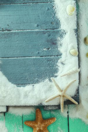 Summer background. Wooden background with white sand and seashells. Shells, starfish and sand. Holiday backgroundの写真素材