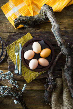 Easter table setting. Fresh eggs on plate. Spring table. Flatlay overhead shot