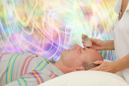 Balancing Third Eye Chakra with terminated quartzの写真素材