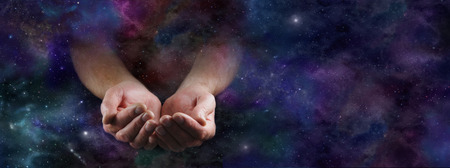 Our Abundant Universe - Male hands emerging from a wide dark deep space background gesturing with cupped hands