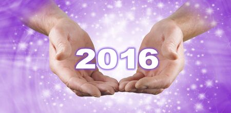 Welcome in 2016 Celebration Banner   -  Male hands open with a white '2016' floating above on a swirling purple pink colored sparkly flowing  background bannerの写真素材