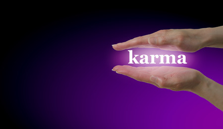 Your Karma is in Your Hands - Female hand parallel with the word 'Karma' floating between on a magenta and black background with plenty of copy spaceの写真素材
