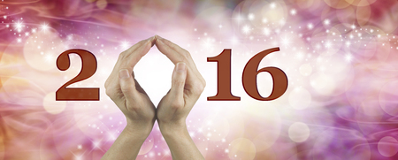 Welcome 2016 with both hands - Female using both hands to make an O in the word 2016 on a warm red and pink colored starry bokeh  backgroundの写真素材