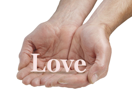 Offering you pure love - male cupped hands offering the word LOVE floating just above his fingers, isolated on a white backgroundの写真素材