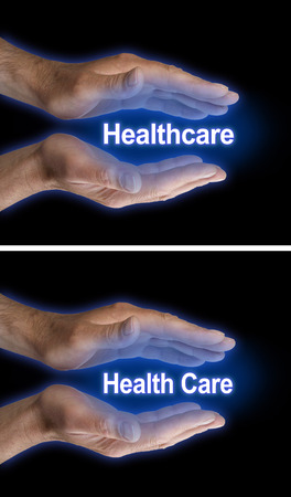 Your Health Care is in Your Hands - two images of male parallel hands with blue glow on a black background, one with Healthcare the other with Health Care floating betweenの写真素材