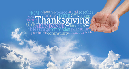 Give and Receive at Thanksgiving - male cupped hands with the word THANKSGIVING to the left surrounded by a word cloud on a beautiful blue sky backgroundの写真素材
