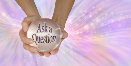 Go on - Ask me a Question - a female holding a large clear crystal ball with ASK A QUESTION within against a feminine pink swishing sparkling background with copy spaceの写真素材