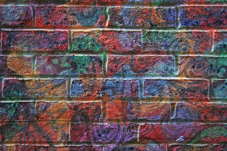 Psychedelic Painted Brick Wall Background - flat view of a coloured graffiti-ed brick wall ideal for use as a grunge backgroundの写真素材