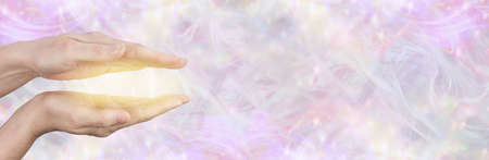 Healing with golden light message banner - female parallel hands with golden light between against a...