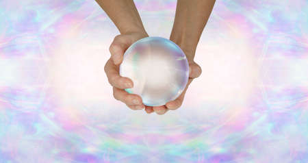 Fortune Teller's crystal ball header background - female holding large clear scrying ball against a...