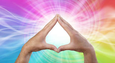 Working with rainbow vortex Healing Energy - male hands making a triangle shape on a rotating...