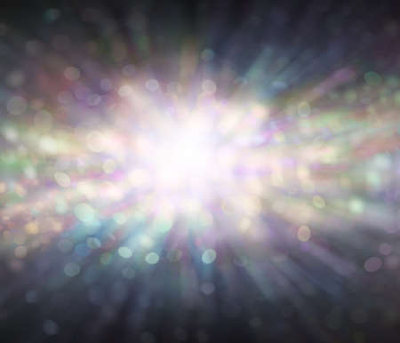 Bursting with energy spiritual background - subtle multicoloured bokeh effect radiating outwards with dark edges and bright centre of pale pastel green, purple, lemon and blueの写真素材