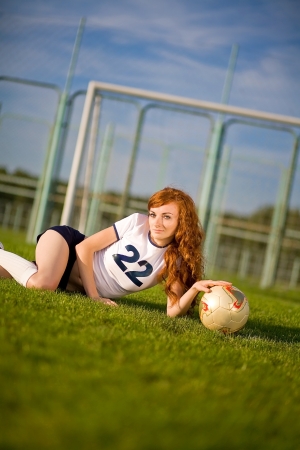Healthy beautiful girl with freckles on soccer fieldの写真素材