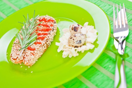 fish with sesame on a green plateの写真素材