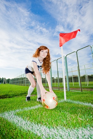 Beautiful redhead girl plays soccerの写真素材