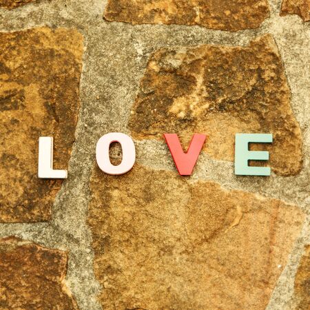 word love made up of colorful wooden letters on a stone floor. February 14, Valentineの写真素材