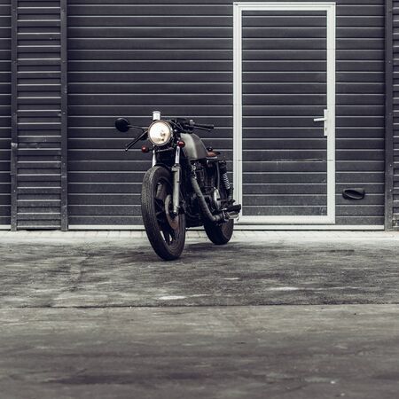 Vintage motorbike parking near finance building. Everything is ready for having fun after hard day in office. Businessman city hipster hobby. Space for your individual text.の写真素材