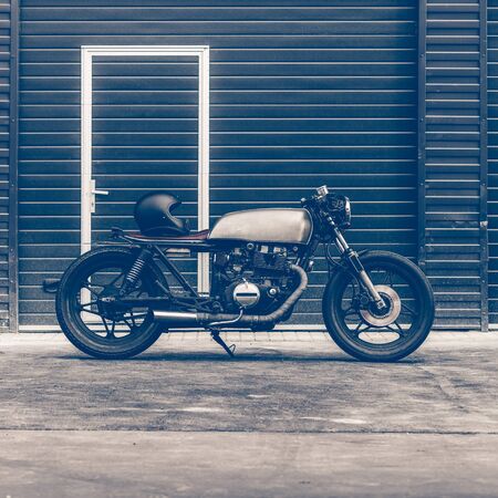 Custom caferacer parking near industrial building. Everything is ready for having fun driving the empty road on a motorcycle tour journey. Hipster city hobby. Space for your individual text.の写真素材