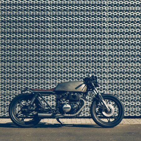 Custom motorcycle parking near wall of industrial building. Everything is ready for having fun driving the empty road on a motorcycle tour journey. Modern man hobby. Space for your individual text.の写真素材