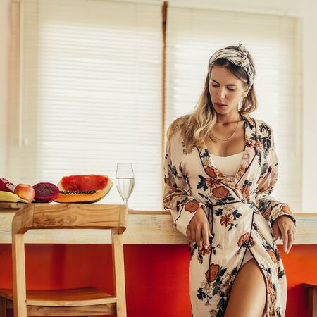 Beautiful young lady in sexy fashion home pajamas on the kitchen posing to camera. Healthy eating lifestyle concept. Health care and beauty. Healthy breakfast. Fitness food. Proper nutrition.の写真素材