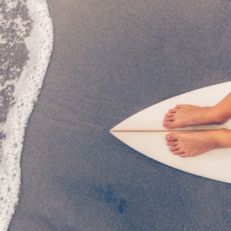 Surf girl with long legs go to surfing. Young surfer woman stay on blank white short surfboard near...