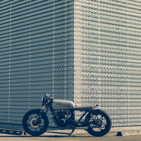 Caferacer motorcycle parking near wall of finance building. Everything is ready for having fun driving the empty road on a motorcycle tour journey. Businessman hobby. Space for your individual text.の写真素材