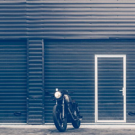 Handmade motorcycle parking near finance building. Everything is ready for having fun after hard day in office. Businessman city hipster hobby. Space for your individual text.の写真素材