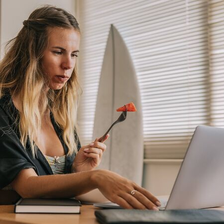 Beautiful young surfer female in sexy black pajamas work with laptop at home. Happy girl working online, study and learn with notebook computer. Modern business lady, freelance work from home concept.の写真素材