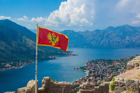Beautiful view from above on the Kotor and Bay of Kotor, Montenegro. Waving in the wind flag of Montenegro on Ancient fortress wall above Kotorのeditorial素材