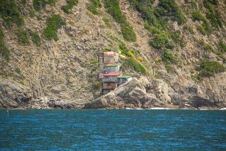 Location between Riomaggiore and Portovenere, view from the excursion boat. Amazing houses built by hand right on the mountain overhanging the sea. National Park of Cinque Terre.の写真素材