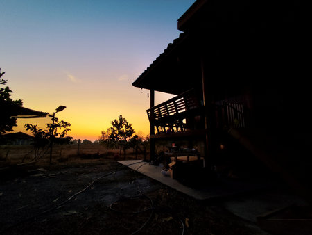 Silhouette of a house at sunset in the countryside of Thailandの写真素材