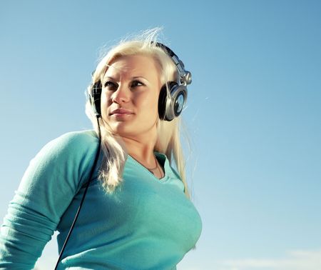 young woman with headphones outdoorsの写真素材