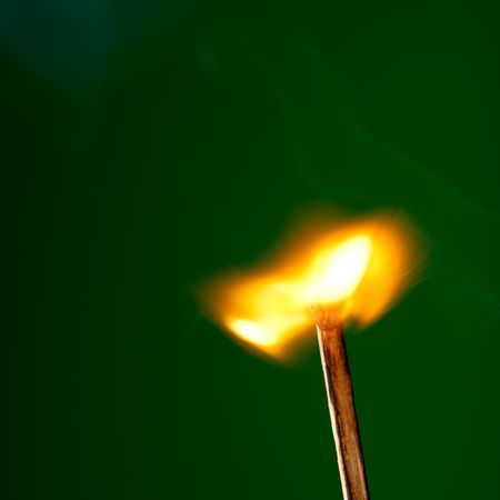 burning match on greenの写真素材