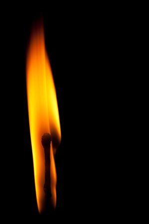 igniting match with tongue of flame on black