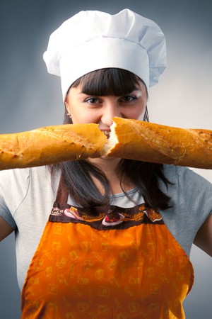 woman cook breaking a french breadの写真素材