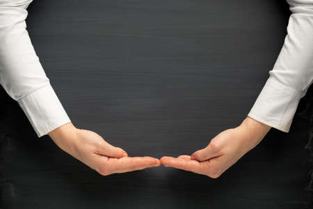 hands surrounding a blackboard backgroundの写真素材