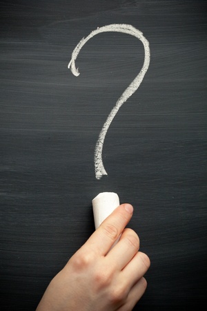 hand drawing with a chalk a question sign on the blackboardの写真素材